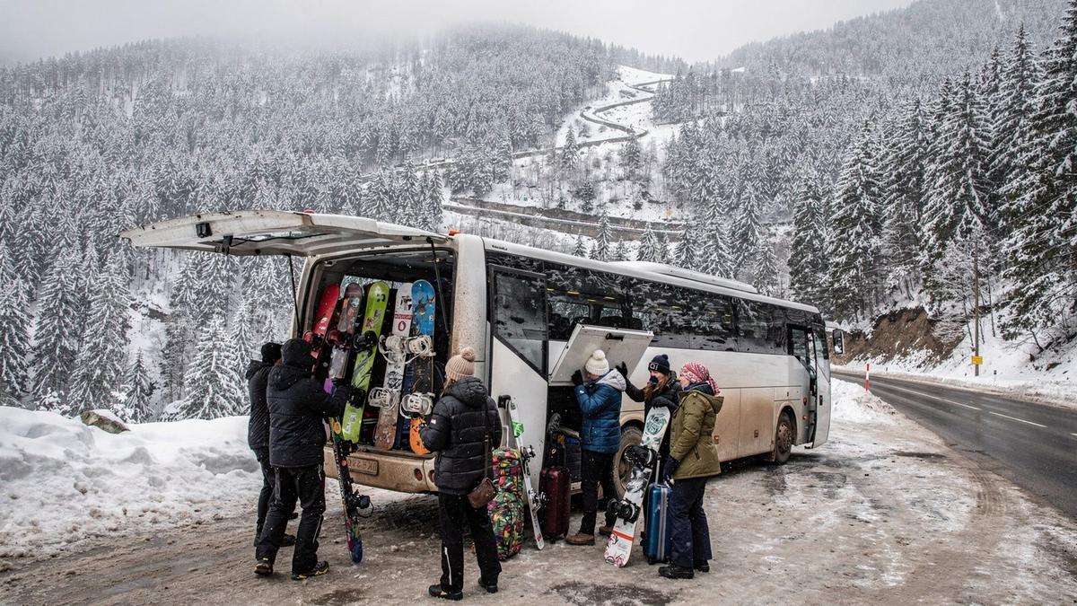Coach loading ski bags at a Carpathian transfer point before the final climb to the resort